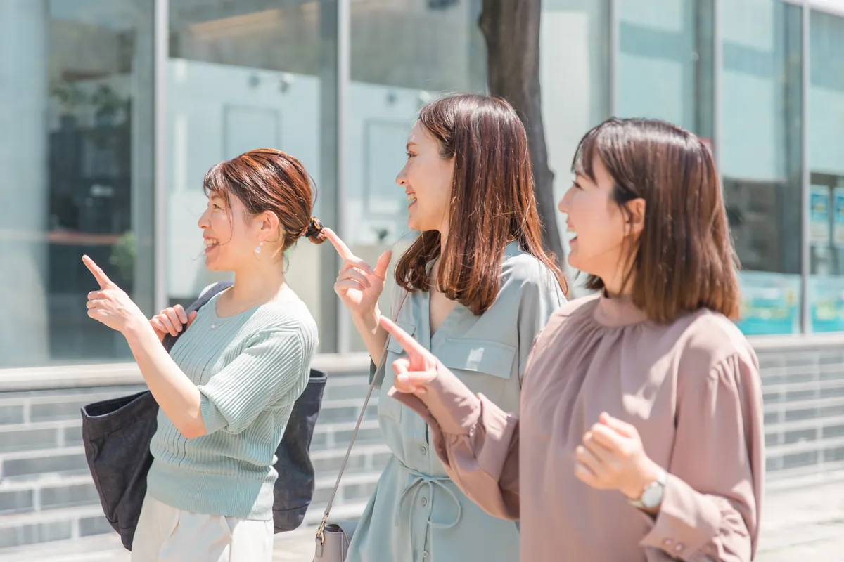 街を指さしながら歩く3人の女性